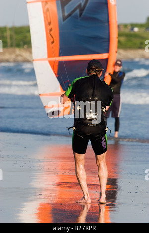 Eine Kite Boarder in einen Neoprenanzug startet seinen Kite am zweiten Strand Aquidneck Insel, Middletown, Rhode Island Stockfoto