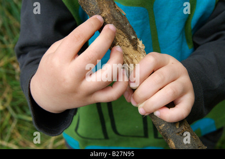 Ein Kleinkind, das Spiel mit einem Holzstab Stockfoto