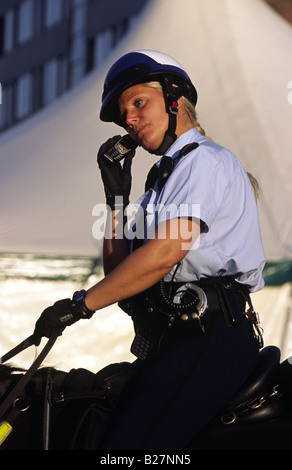 Polizistin auf Pferd telefonieren mit ihrem Handy. Amsterdam, Niederlande. Stockfoto