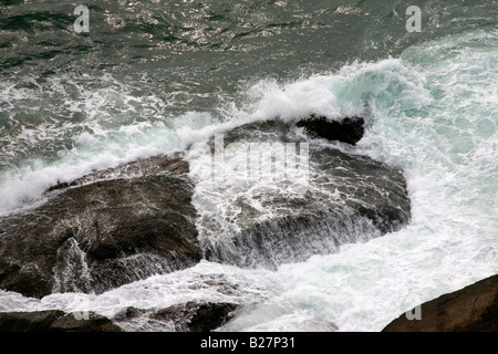 Felsen und Wellen am Strand von Kovalam, Kerala, Indien Stockfoto