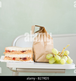 Sandwich und Trauben neben Papiertüte Stockfoto