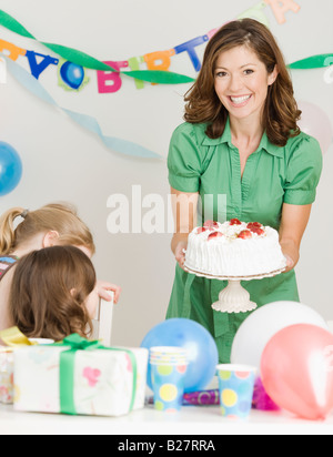 Mutter hält Geburtstagstorte auf party Stockfoto