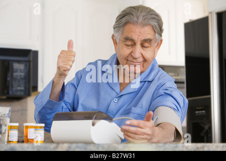 Senior woman die eigenen Blutdruckmessung Stockfoto