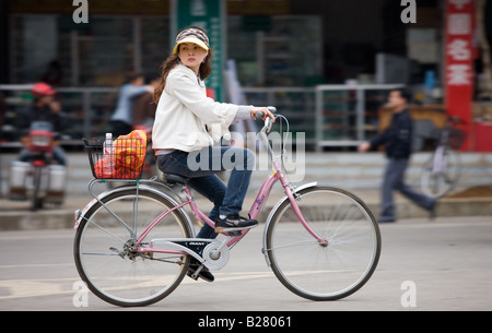 Junge Frau auf einem Fahrrad in Yangshuo Straße China Stockfoto