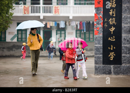 Frauen und Mädchen verlassen den Spielplatz einer Grundschule in Fuli China hat eine Kindpolitik Bevölkerung zu begrenzen Stockfoto