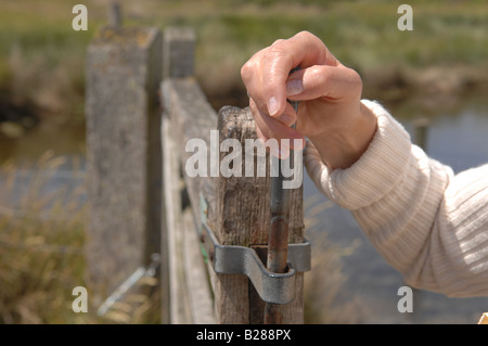 Eine Frau geht durch ein Tor in den sieben Schwestern Country Park Stockfoto