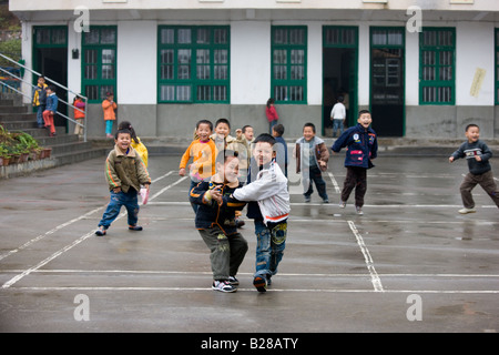 Kinder auf dem Spielplatz der Grundschule in Fuli China hat eine Kindpolitik Bevölkerung zu begrenzen Stockfoto