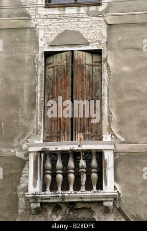 Eine verblasste Balkon und Fensterläden Tür mit Blick auf einen Kanal in Venedig Italien Stockfoto