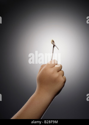 Ein Kind Hand hält eine gewinnende Querlenker Stockfoto