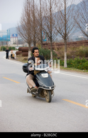 Mann und Kind auf einem Roller in der Nähe von Guilin China China hat eine eine Kindpolitik Familienplanung, Bevölkerung zu verringern Stockfoto