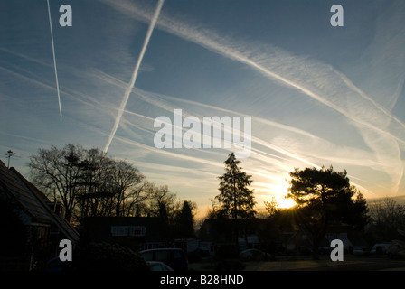 Mehrere Kondensstreifen von Flugzeugen am Himmel zeigen die Flugbahn über Midhurst, Sussex, UK, Sunrise Stockfoto