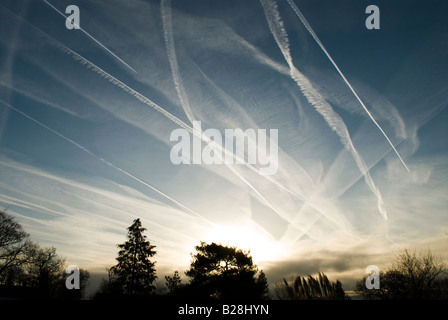 Mehrere Kondensstreifen von Flugzeugen am Himmel zeigen die Flugbahn über Midhurst, Sussex, UK, Sunrise Stockfoto