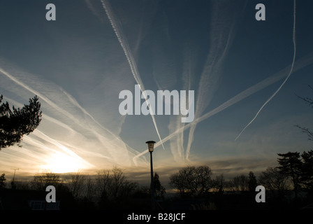 Mehrere Kondensstreifen von Flugzeugen am Himmel zeigen die Flugbahn über Midhurst, Sussex, UK, Sunrise Stockfoto