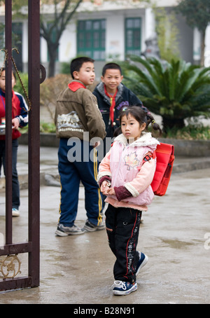 Jungs schauen Mädchen verlassen den Spielplatz einer Grundschule in Fuli China hat eine Kindpolitik Bevölkerung zu begrenzen Stockfoto