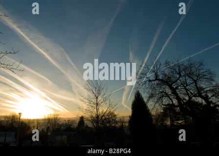 Mehrere Kondensstreifen von Flugzeugen am Himmel zeigen die Flugbahn über Midhurst, Sussex, UK, Sunrise Stockfoto