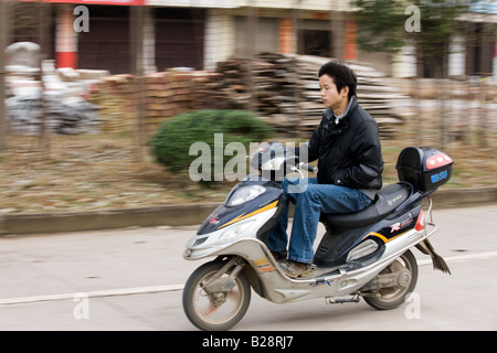 Mann auf einem Roller in der Straße in der Nähe von Guilin, China Stockfoto