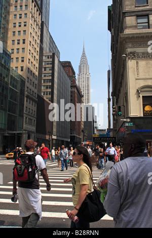 Fußgänger überqueren 5th Avenue mit Chrysler Gebäude im Hintergrund - New York City, USA Stockfoto