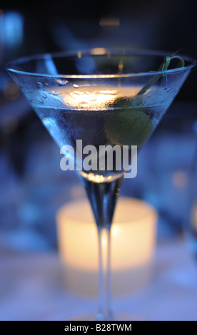 Foto von einen Martini mit Oliven, mit Feuchtigkeit in der Hitze des Sommers, in das Candle-light Restaurant schimmernde Perlen Stockfoto