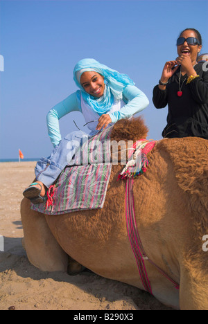 Omanische Mädchen nehmen einen Kamelritt in Al Sawadi Beach Resort Stockfoto