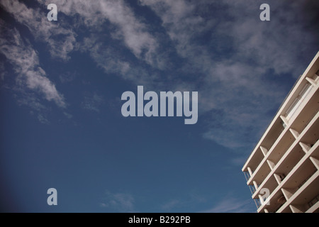 Reiche blauer Himmel mit streifigen Wolken und weißes Gebäude Stockfoto