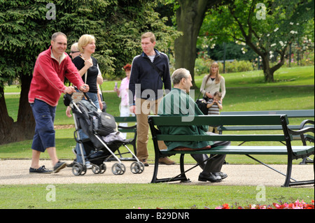 Menschen im Park: Ein Vater schiebt einen Buggy wie die Familie durch Sheffield Botanical Gardens spazieren. Stockfoto