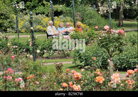 Menschen In den Park: Menschen im Park: Eine Gruppe älterer Menschen, die auf einer Bank sitzend bewundern die Rosengärten im botanischen Gard Stockfoto