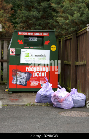 Bank in Schottland UK Beschaffung von Mitteln für Barnardos Kinder Charity mit drei Papier und Pappe recycling Plastiktüten Kleidung Stockfoto