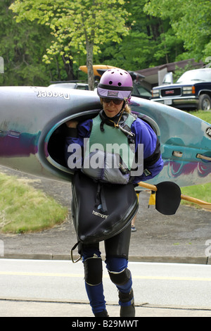 Frau, die ihr Kanu bis auf den Rand des Wassers in Ohiopyle Pennsylvania Stockfoto