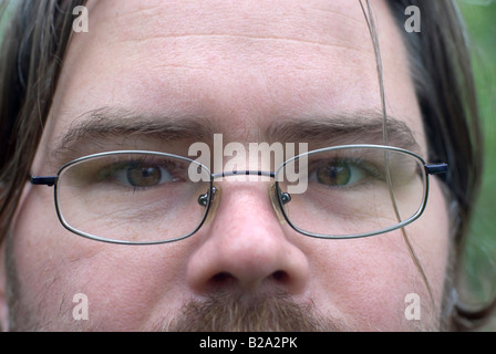 Junger Mann mit langen Haaren mit Brille Stockfoto