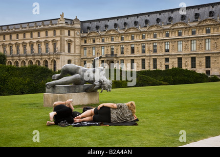 Eine weibliche Touristen liegen auf Gras imitiert Pose der Statue Skulptur auf der grünen Wiese von den Tuilerien am Louvre, während Freund Bild Sommer in Paris nimmt Stockfoto