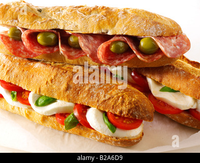 Verschiedene belegte Brötchen vor einem weißen Hintergrund - Olivenöl und Salami Baguette, Mozzarella und Tomaten Baguette Stockfoto