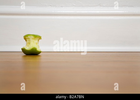 Ein Apfel gegessen gegen eine weiße Sockelleiste erschossen Stockfoto