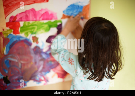 Fünf Jahre altes Mädchen klebt Kunstwerke auf ihr Schlafzimmer Pinnwand Mischlinge indischen ethnischen Stockfoto