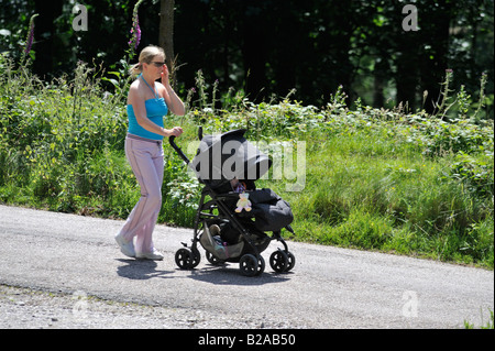 Mutter drängt Kind im Buggy heraus für einen Spaziergang entlang der vielen schönen und interessanten Wege des Upper Derwent Valley. Stockfoto