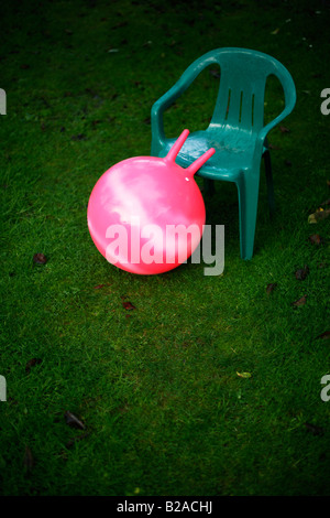 Rosa Moonhooper auf grünen Garten Rasen mit Kunststoff-Stuhl Stockfoto