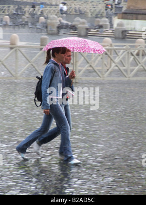 zwei Freunde teilen Regenschirm bei starkem Regen in der Stadt Stockfoto