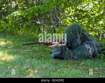 Scharfschütze im Ghillie Anzug mit.22 Kaliber Gewehr mit dem Ziel Sie Rahmen Stockfoto