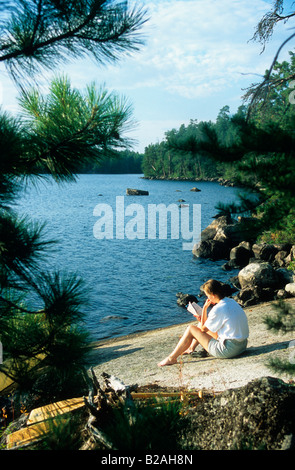 Frau Entspannung am Campingplatz auf Cummings See, Boundary Waters Canoe Area, Minnesota Stockfoto