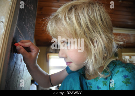 Junges Kind an Tafel schreiben Stockfoto