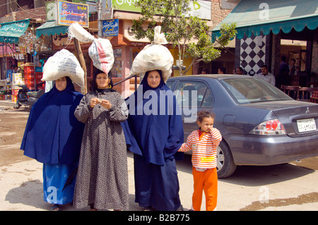 Frauen des Dorfes tragen Pakete auf ihren Köpfen in den Märkten des Dorfes El Fayoum Ägypten Stockfoto