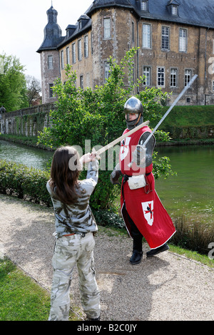 Junges Mädchen Schwertkampf gegen einen Mann, gekleidet in ein mittelalterlicher Ritter Rüstung und Kleidung während der Renaissancefest oder Renais Stockfoto