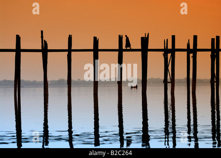 Mönche der U Bein Brücke bei Sonnenuntergang, alten hölzernen Teak zu überbrücken, Mandalay, Myanmar, Südostasien Stockfoto