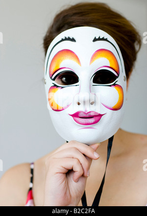 junge Frau hinter der Maske Stockfoto