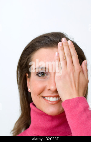 junge Frau Porträt, hielt ihre Hand vor ein Auge Stockfoto