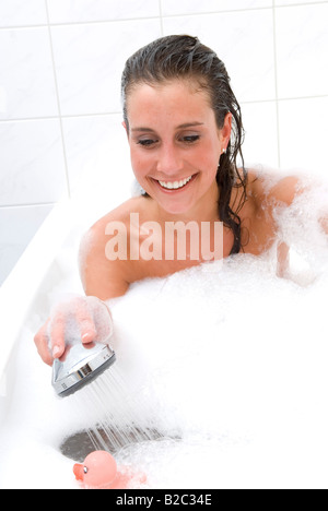 Junge Frau in der Badewanne spielen mit Dümpelfried Enten Stockfoto