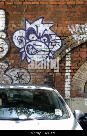 Auto geparkt vor einem Wandgemälde eines Affen an gemauerten Wand, London Stockfoto
