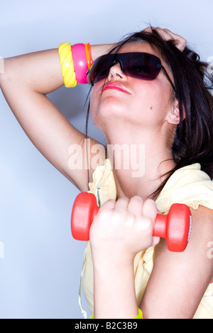 junge Frau mit Sonnenbrille und Langhantel Stockfoto