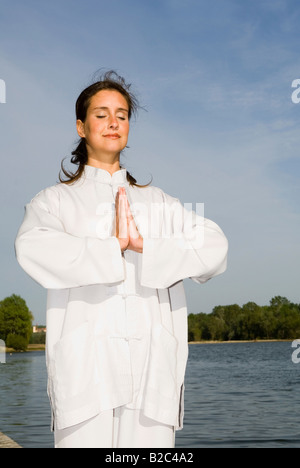 Junge Frau, die sich darin üben, Qi Gong, Kreis Stockfoto