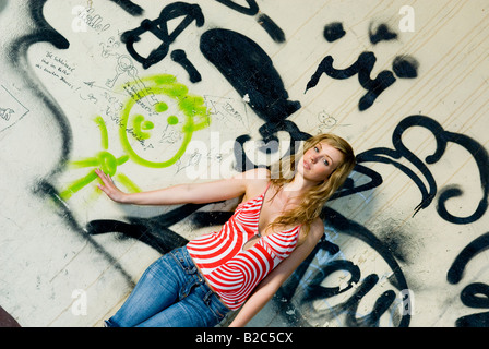 junge Frau, die Hand in Hand mit einem bemalten Graffiti-Mann Stockfoto