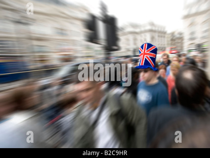 Mann mit Hut der Anschluß-Markierungsfahne in überfüllten Piccadilly Circus London Stockfoto